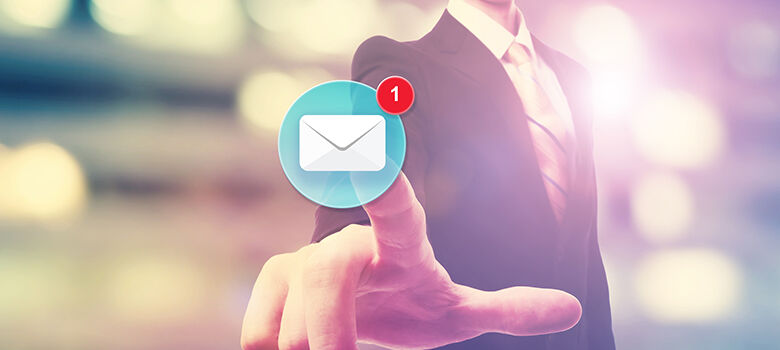 Businessman pointing at an email icon on blurred city background